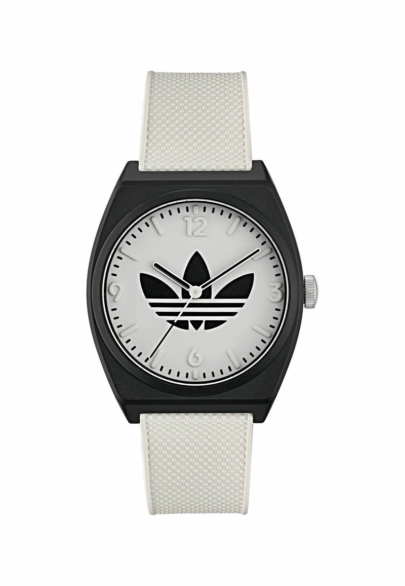 Montre rectangulaire noire avec bracelet en silicone blanc. Le cadran argenté présente un logo noir, des repères horaires à 12 et 6 heures, et un design minimaliste.