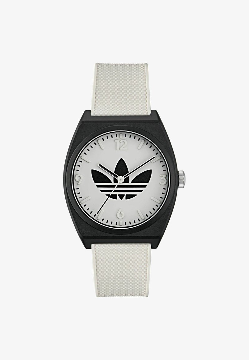 Mustaline musta ruudukujuline kell valge silikoonist rihmaga. Hõbedane kellapäeval on must logo, tunni näitajad 12. ja 6. kohal ning minimalistlik disain.