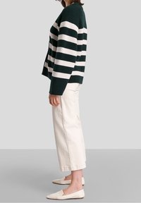 Vihreä ja valkoinen raidoitettu neuletakki, pehmeä neulemateriaali, rento malli. Yhdistetty vaalean kermanvärisiin leveälahkeisiin housuihin ja vaaleisiin liukuviin kenkiin.