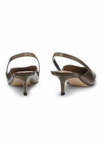 Scarpe slingback in pelle lucida verde oliva con tacco basso Christian e accentuazione nera sulla suola; dotate di una fibbia decorativa sul lato.