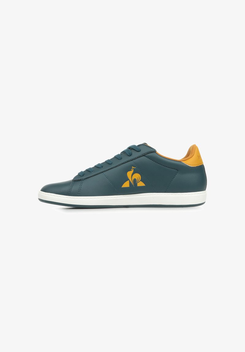 Teal leren sneaker met witte zool, oranje accenten en stikdetails. Bevat een logo aan de zijkant en een klassiek vetersluitingontwerp.