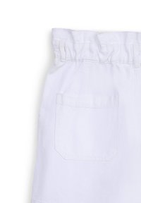 Jupe blanche avec une taille haute style paperbag, passants de ceinture et une seule poche plaquée à l'arrière sur fond uni.