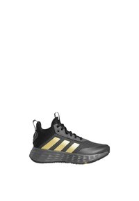 Black athletic shoe with golden stripes, mesh upper, textured rubber outsole, and reinforced heel tab. Features laces and contrasting accents.