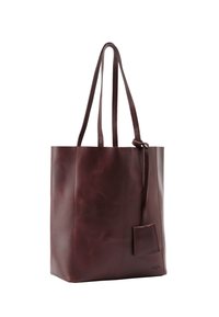 Borsa tote in pelle borgogna con due manici lunghi, texture liscia e un piccolo cartellino attaccato; presenta un design minimalista e senza hardware visibile.