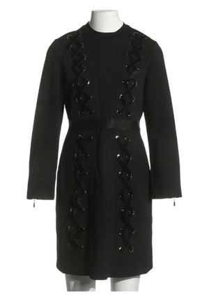 Robe noire à manches longues avec des détails de rubans brillants croisés verticalement sur le devant et des fermetures éclair aux poignets.