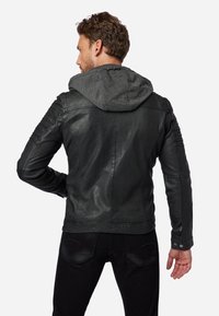 Svart läderjacka med grå huva, texturerade axeldetaljer och en figursydd design. Har en slät yta och detaljerad sömnad.