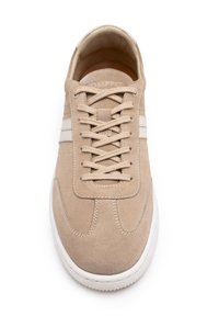 Sneaker in suede beige con due strisce bianche. Caratterizzato da punta arrotondata, lace piatti e suola in gomma testurizzata. Design semplice e pulito.