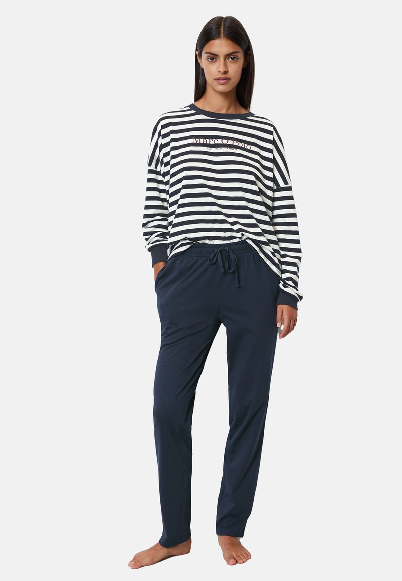 Gestreepte langharige top in marineblauw en wit, met logo detail, gecombineerd met marineblauwe broek met trekkoord met een relaxte pasvorm en een gladde textuur.
