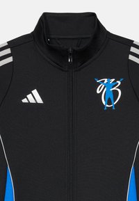 Černá sportovní zipová bunda s šedými pruhy na ramenou, modrými akcenty a modrým logem postavy. Hladká textura, přiléhavý design.