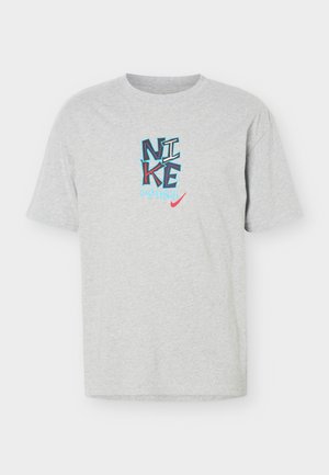 Camiseta gris claro de manga corta con texto colorido "NIKE Basketball" y un logo rojo de Nike swoosh centrado en el pecho.