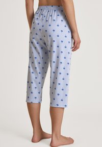 Blauwe en witte gestreepte capri-broek met een palmbomenpatroon, voorzien van een elastische tailleband en een ontspannen pasvorm, gemaakt van lichtgewicht stof.