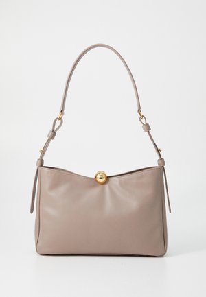 Beige leather handbag with a curved top, a gold round clasp, and an adjustable shoulder strap. Smooth texture with minimalistic design.