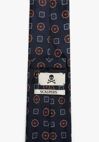 Corbata navy con un patrón floral en burdeos y azul. Presenta un parche con un logo de calavera y huesos cruzados, etiquetado como "SCALPERS". Textura suave.