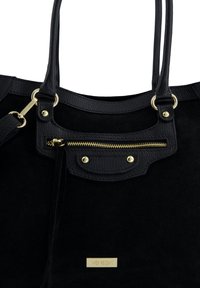 Czarna zamszowa torebka z akcentami ze skóry, złotymi okuciami, kieszenią na zamek oraz podwójnymi uchwytami ułatwiającymi noszenie. Widoczna metka z logo marki.
