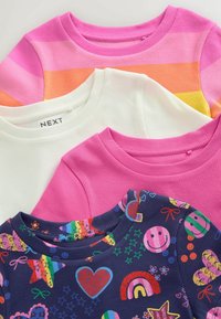 Štyri detské tričká s okrúhlym výstrihom a rebrovaným vzorom, navrstvené: ružové pruhy, jednofarebná biela, ružová a námornícka modrá s farebnými srdiečkami, dúhami a hviezdami.