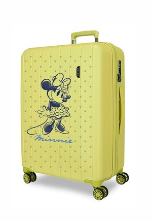 Maleta dura amarilla con cuatro ruedas giratorias, un asa retráctil y un gran dibujo negro de Minnie Mouse en el panel frontal.