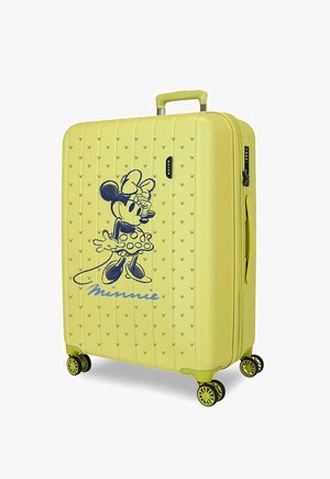 Maleta dura amarilla con cuatro ruedas giratorias, un asa retráctil y un gran dibujo negro de Minnie Mouse en el panel frontal.