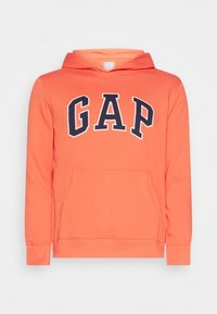 Sudadera color coral con bolsillo tipo canguro en la parte frontal y gran logotipo en azul marino "GAP" en letras de bloque en el pecho.