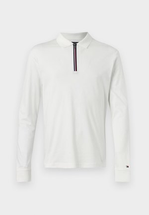 Polo bianco a maniche lunghe con collo con zip, caratterizzato da una striscia decorativa nera, rossa e blu. Materiale in cotone morbido, vestibilità standard.