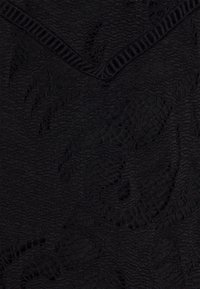 Tessuto nero con texture e un sottile motivo floreale, con bordi rigati, caratterizzato da un tessuto morbido e leggero adatto per abbigliamento o accessori.