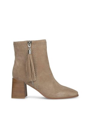 Botte de cheville en suède taupe avec un bout pointu, accents en clous argentés, fermeture éclair latérale et un détail en frange sur la tirette de la fermeture. Talon empilé en bois.