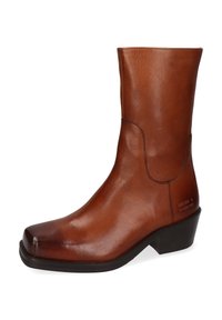 Stivaletto alla caviglia in pelle marrone con punta quadrata, texture liscia, tacco basso impilato e marchio discreto sul lato. Design classico con accenti minimalisti.