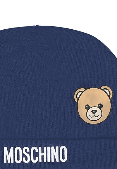 Berretto di lana blu navy con un patch a forma di faccia di un orso bruno. Il nome del marchio "MOSCHINO" è mostrato in lettere bianche in grassetto sul davanti.