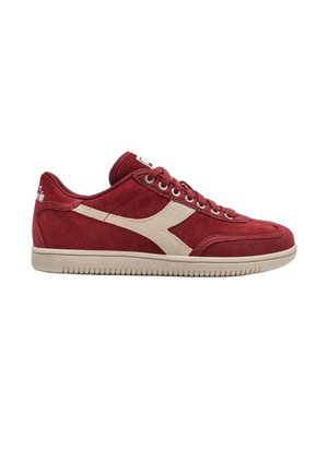 Rode suède sneaker met beige zool, beige zijstreep, veters en zichtbare stiksels. De schoen is van opzij te zien op een witte achtergrond.