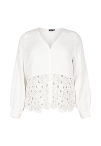 Vit blus med lång ärm, V-ringning, knappstängning fram och en texturerad spetsnederdel med cirkulära mönster.