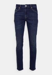 Tumma sininen farkut, joissa on slim fit -leikkaus, viisi taskua, vetoketju ja hienovaraiset ompeluyksityiskohdat. Sujuva pinta, jossa on vain vähän haalistumista.