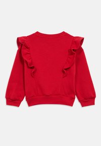 Czerwona bluza z falbankami na ramionach, okrągłym dekoltem i ściągaczami na mankietach. Wykonana z miękkiego, teksturowanego materiału.