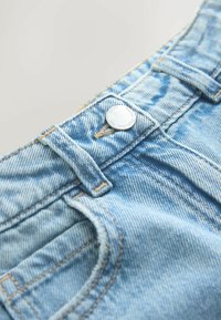 Šviesiai mėlyni džinsiniai šortai su sidabro spalvos sagos užsegimu, matomomis siūlėmis ir atvira kišenės detale. Minkšta tekstūra ir laisvalaikio dizainas.