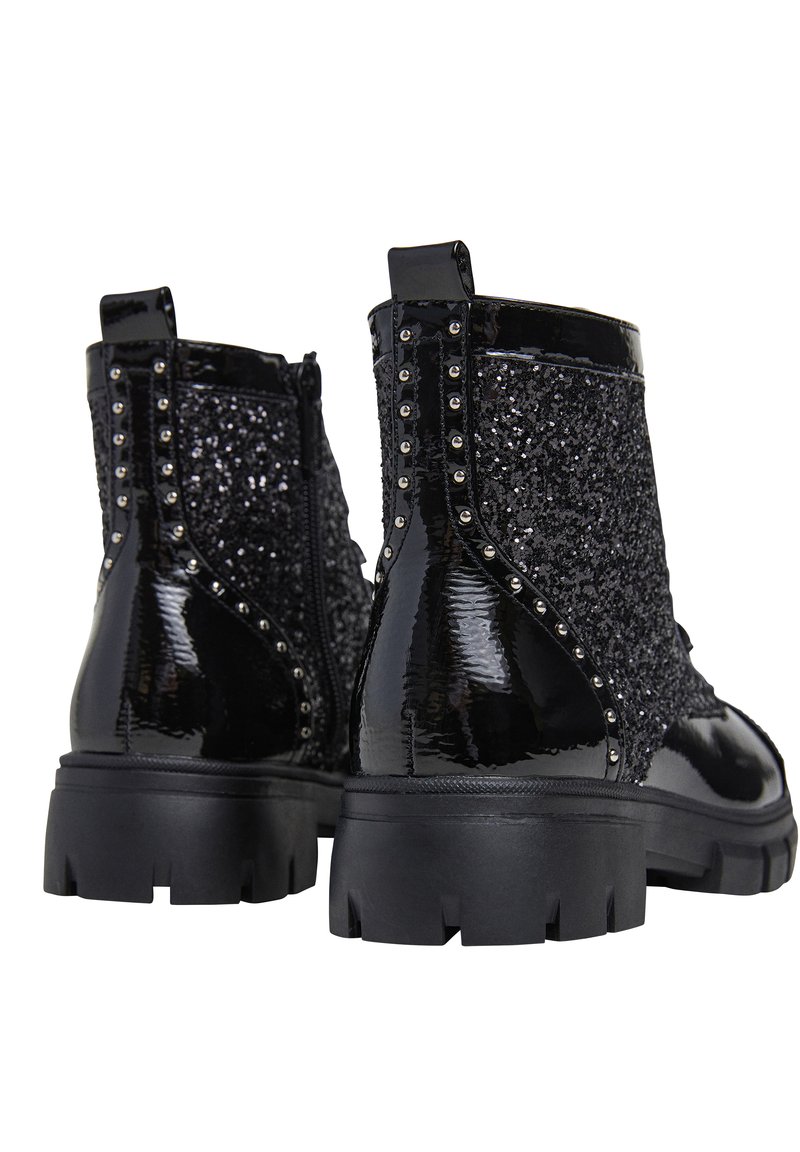 Zwarte enkelboots met een glanzende patinafinish, versierd met zwarte pailletten en zilveren studs, stevige rubberen zool, met ritssluiting aan de zijkant.