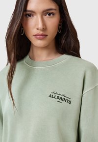 Felpa verde realizzata in morbido tessuto, caratterizzata da un collo rotondo e una vestibilità comoda. Testo nero "Infinite Summer AllSaints London" sul davanti.