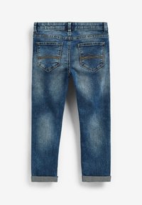Jeans de mezclilla azul con corte recto, que presentan dos bolsillos traseros, un ligero desvanecimiento y puños enrollados. Las costuras acentúan el diseño de los bolsillos.