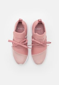 Różowe buty sportowe z gładką górą i teksturowanymi akcentami z siateczki. Posiadają okrągły czubek i płaską białą podeszwę. Sznurówki są związane w kokardę.