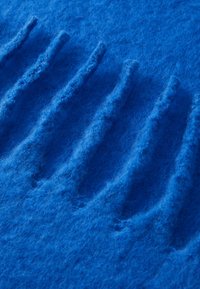 Textil din fetru albastru cu striuri ridicate și texturate. Suprafața este moale și pufoasă, prezentând o culoare uniformă și elemente tactile constante.