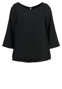 Blouse noire à manches longues avec un col rond et un ourlet légèrement superposé, dotée d'une petite fermeture à bouton dans le dos.