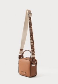 Geantă dreptunghiulară din piele maro, cu mâner superior și o curea texturată bej, având logo-ul "Karl Lagerfeld". Accente din metal argintiu.