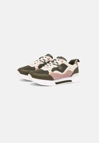 Un par de zapatillas deportivas en verde oliva, rosa y beige con suelas y cordones blancos, posicionadas en un ligero ángulo sobre un fondo claro.