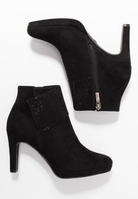 Musta mokkanahka nilkkurit, joissa on rytmitetty, niititetty paneeli ja sivuvetoketju. Ominaisuuksiin kuuluu korkea, hoikka korko ja pyöreä kärki.