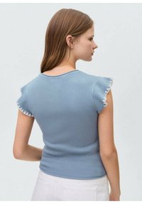 Top albastru cu dungi, cu mâneci scurte și volănașe, și decolteu rotund. Material texturat cu o siluetă ajustată, potrivit pentru îmbrăcăminte casuală.