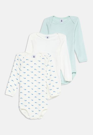 Drei Babybodys mit langen Ärmeln, eines hellblau, eines weiß und eines weiß mit einem blauen Wal-Muster.