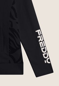 Giacca sportiva nera con un design testurizzato, polsini a costine e la parola "FREDDY" in audace lettering bianco sulla manica.