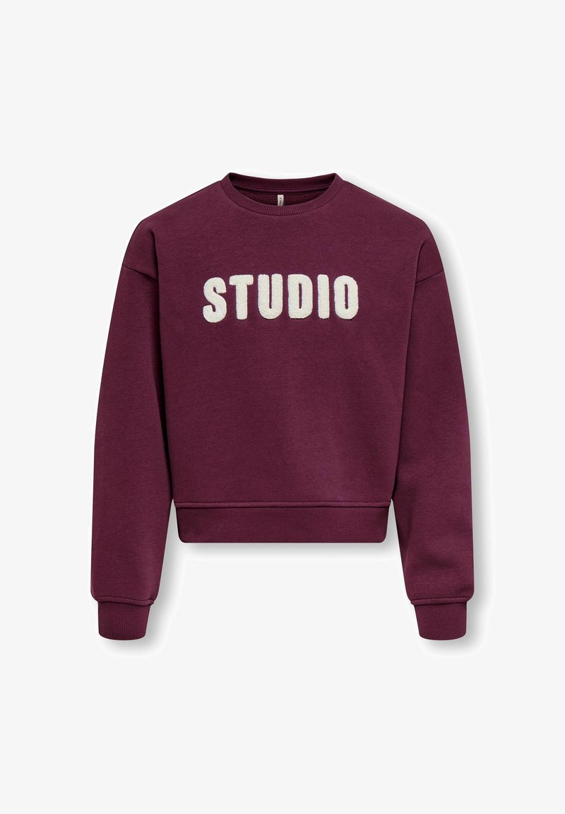 Sweat-shirt bordeaux à col rond avec manches longues et lettres blanches épaisses et texturées formant le mot « STUDIO » sur la poitrine.