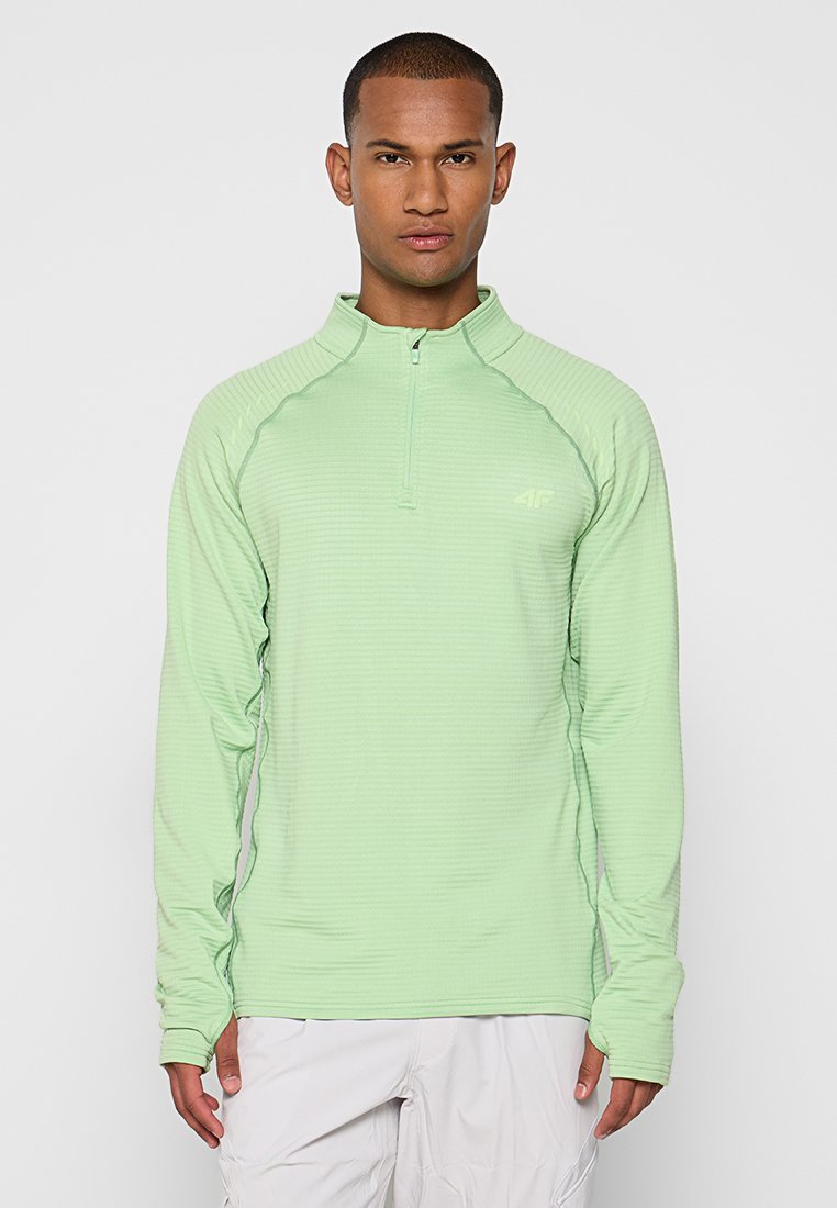 Haut à manches longues vert clair avec zip quart en tissu texturé, présenté avec des manches raglan. Doté d'un logo subtil sur la poitrine et de coutures plates.