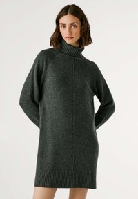 Vestito grigio a collo alto realizzato in morbido tessuto a maglia. Caratterizzato da orli e polsini a coste, con una vestibilità comoda e dettagli laterali.