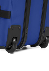 Valigia blu con ruote, dotata di un esterno in tessuto resistente, dettagli in plastica nera e quattro ruote scorrevoli per una facile mobilità.