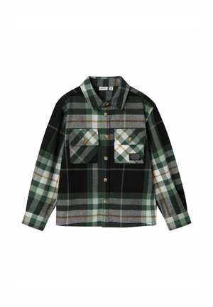 Chemise à carreaux verte, noire et blanche, avec deux poches poitrine, des manches longues et un col, posée à plat sur un fond blanc.