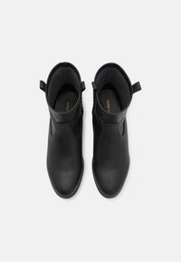 Bottines en cuir noir au design élégant, bout arrondi, fermetures éclair sur le côté et languettes pour un enfilage facile. Doublure intérieure douce.